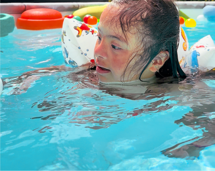 Mädchen schwimmt mit Schwimmflügeln